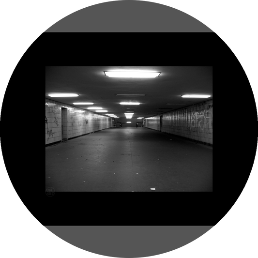 un4rt - a black and white photographie of a former underground trespas that once was part of the train station "alexanderplatz" in berlin. graffities on the walls, trash on the ground.