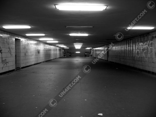 un4rt - a black and white photographie of a former underground trespas that once was part of the train station "alexanderplatz" in berlin. graffities on the walls, trash on the ground.