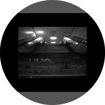 un4rt - a black and white photographie of a former underground trespas that once was part of the train station "alexanderplatz" in berlin. stairway. graffities on the stairs and the walls.