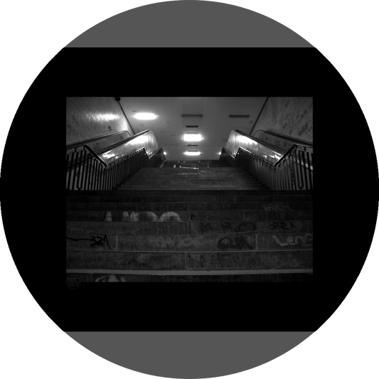un4rt - a black and white photographie of a former underground trespas that once was part of the train station "alexanderplatz" in berlin. stairway. graffities on the stairs and the walls.