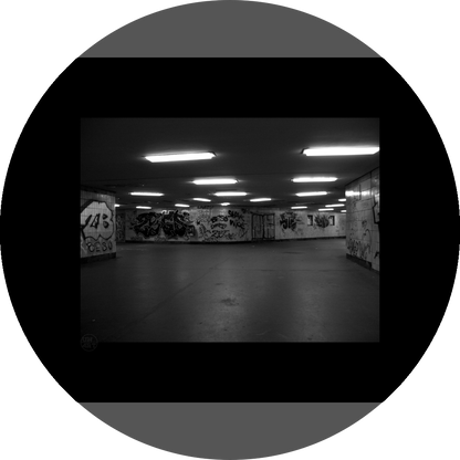 un4rt - a black and white photographie of a former underground trespas that once was part of the train station "alexanderplatz" in berlin. big graffities on the wall. 