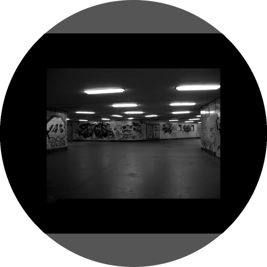 un4rt - a black and white photographie of a former underground trespas that once was part of the train station "alexanderplatz" in berlin. big graffities on the wall. 