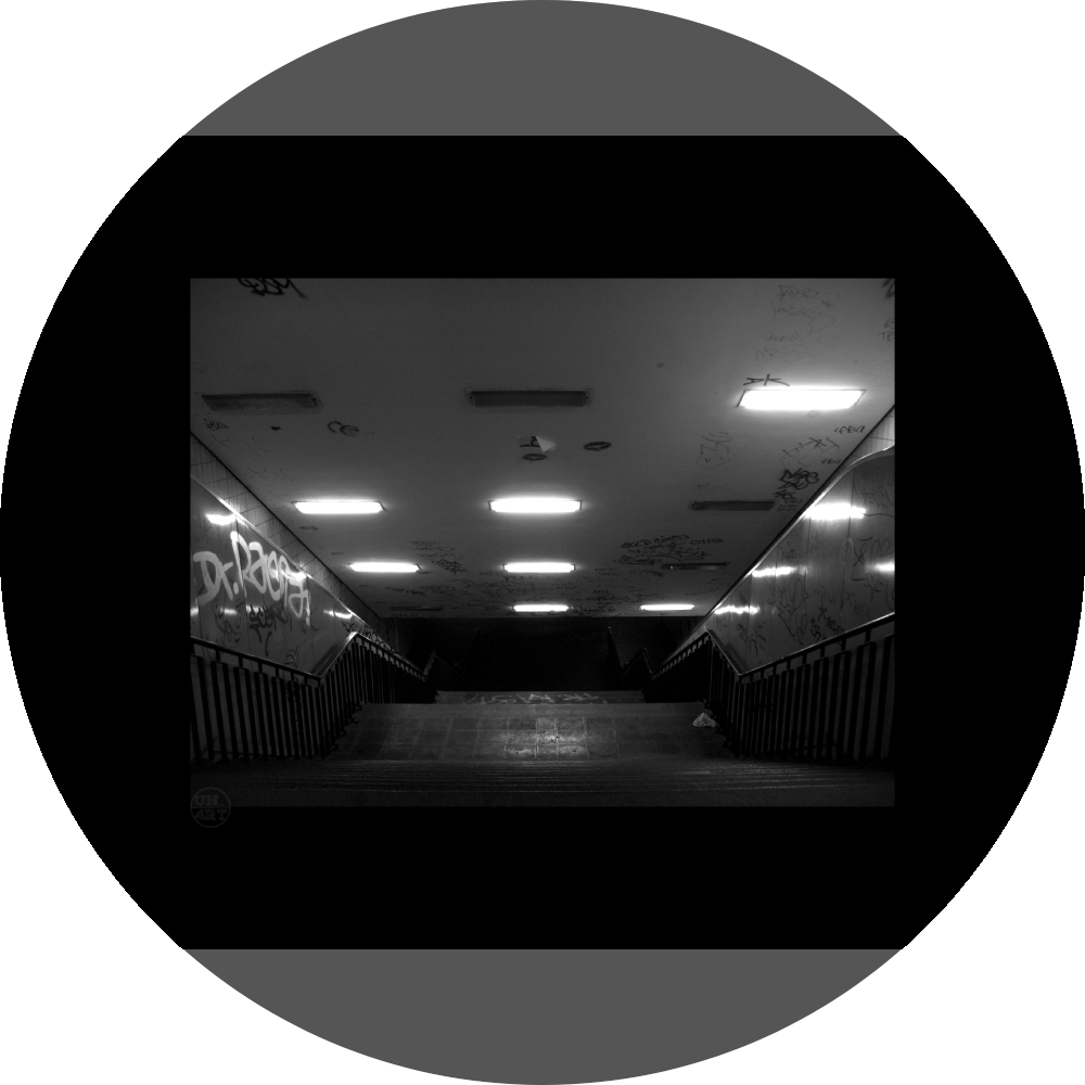 un4rt - a black and white photographie of a former underground trespas that once was part of the train station "alexanderplatz" in berlin. a stairway that is leading down. graffities on the ceiling and the wall. 