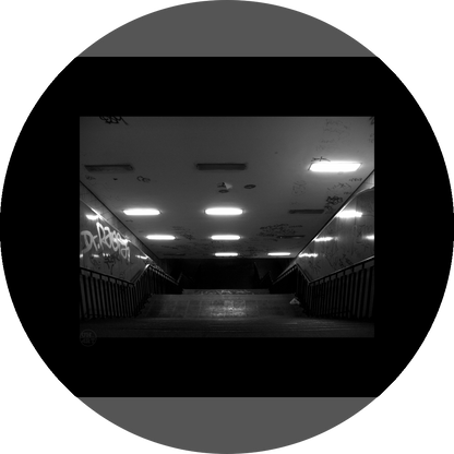 un4rt - a black and white photographie of a former underground trespas that once was part of the train station "alexanderplatz" in berlin. a stairway that is leading down. graffities on the ceiling and the wall. 