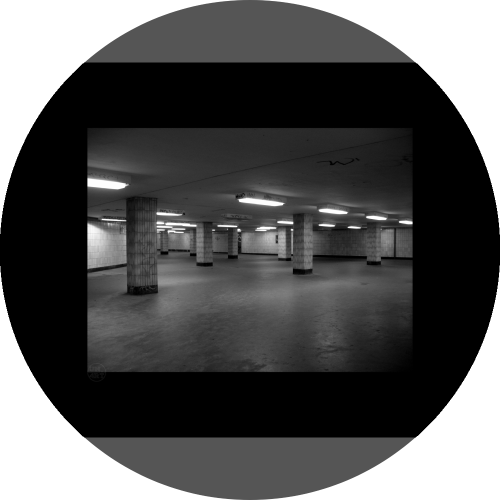 un4rt - a black and white photographie of a former underground trespas that once was part of the train station "alexanderplatz" in berlin. tiled square columns support the ceiling. graffities on the columns and the ceiling.