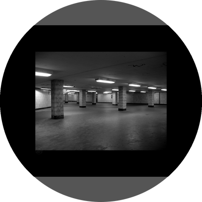 un4rt - a black and white photographie of a former underground trespas that once was part of the train station "alexanderplatz" in berlin. tiled square columns support the ceiling. graffities on the columns and the ceiling.