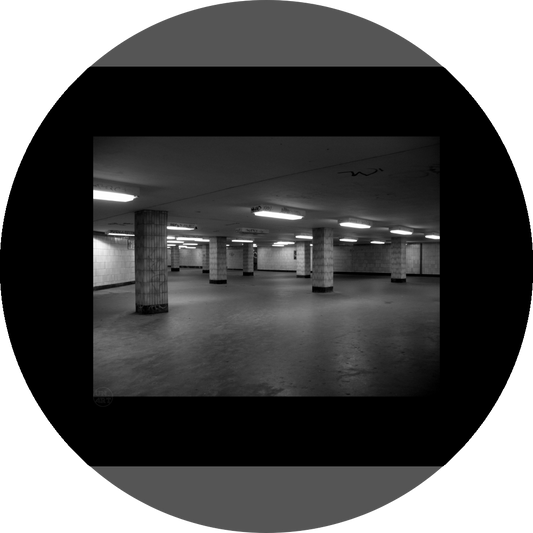 un4rt - a black and white photographie of a former underground trespas that once was part of the train station "alexanderplatz" in berlin. tiled square columns support the ceiling. graffities on the columns and the ceiling.