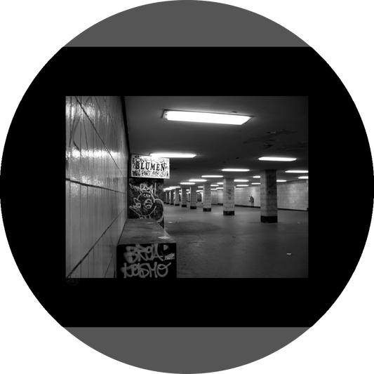 un4rt - a black and white photographie of a former underground trespas that once was part of the train station "alexanderplatz" in berlin. tiled square columns support the ceiling. the left wall also has a porch of an old flower shop. the porch is full of graffities and the sign of the shop advertises "blumen".