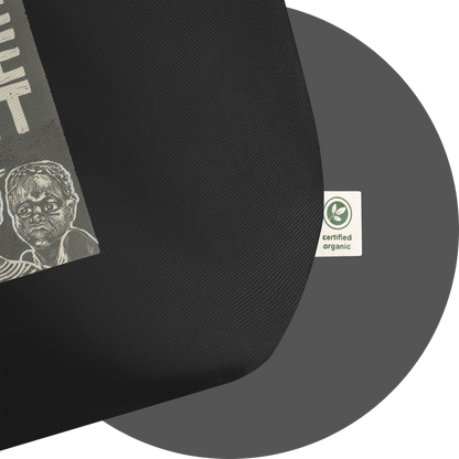 un4rt - the image shows details of a black certified organic cotton tote bag with parts of a print. a white label is attached to the tote bag. the print n the label reads: "certified organic".