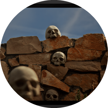 un4rt - the photographie shows a chaotic decorative stone wall with skulls in and on top of it. chemtrails in the sky starting to cover the natural blue of the sky.. one blurry skull in the foregrund.