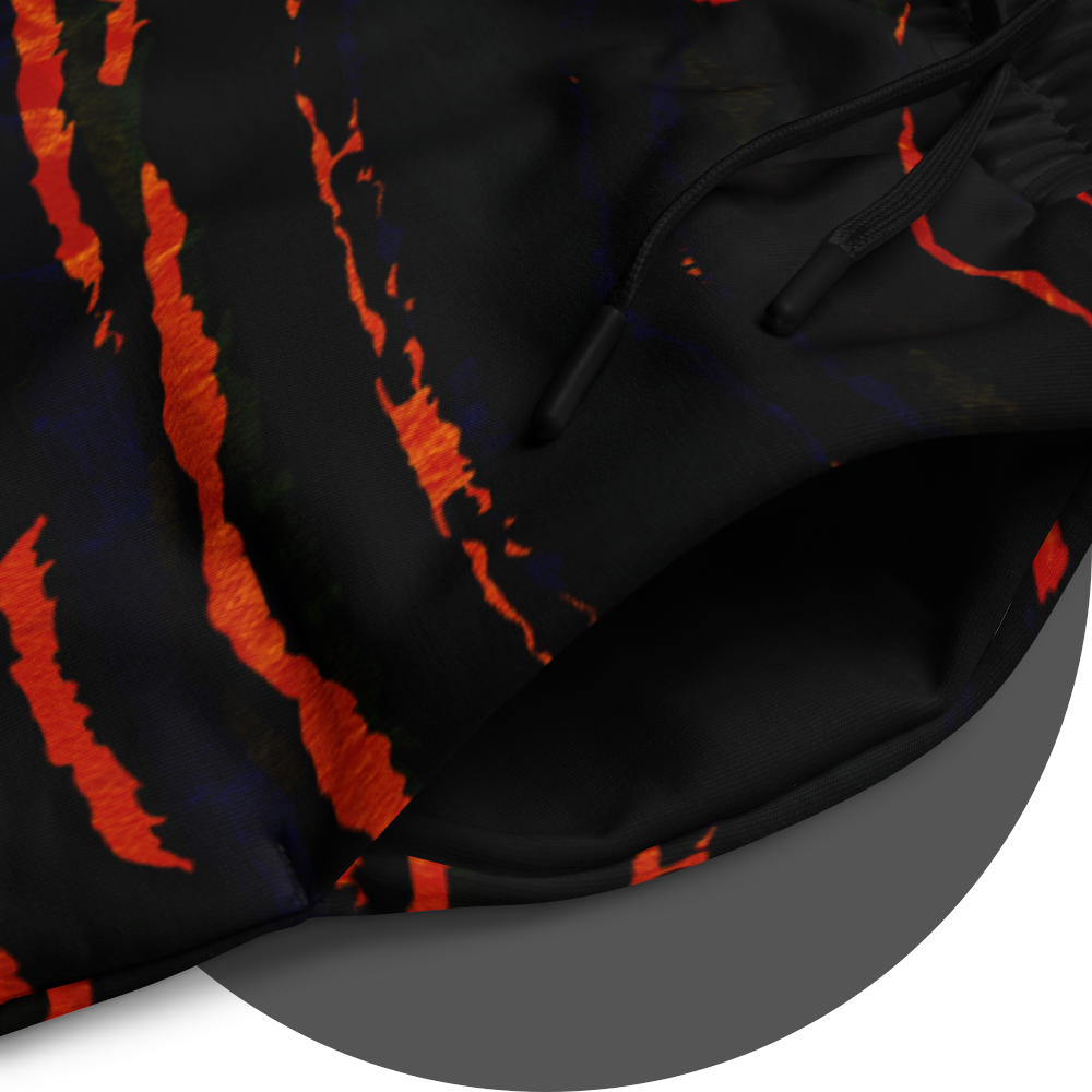 UN4RT tiger lily jogging pants detail – close-up of all-over-print showing fiery orange-red claw scratch pattern on black fabric, elasticated drawstring waistband visible, bold dark art streetwear design.