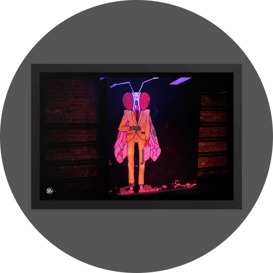 un4rt - the photographie shows a mural of a humanoid insect in a suit with a briefcase on a black wall. the creature is looking at a watch on his wrist. on both side of the black wall there re brick walls with fixed steel pipes. the creature is colorful with a yellow suit, red eyes colored wings and a white head.