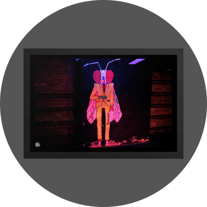 un4rt - the photographie shows a mural of a humanoid insect in a suit with a briefcase on a black wall. the creature is looking at a watch on his wrist. on both side of the black wall there re brick walls with fixed steel pipes. the creature is colorful with a yellow suit, red eyes colored wings and a white head.