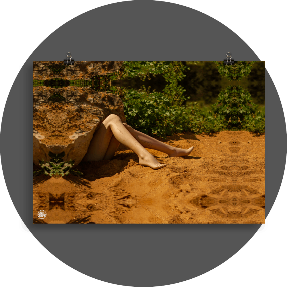 un4rt - a photographie that is mirrored on all sides. the image shows the legs of a mannequin which seems to be stuck under a huge rock. the feet are playing in the sand. wild greenery in the backround. unsharp background.