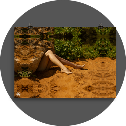 un4rt - a photographie that is mirrored on all sides. the image shows the legs of a mannequin which seems to be stuck under a huge rock. the feet are playing in the sand. wild greenery in the backround. unsharp background.