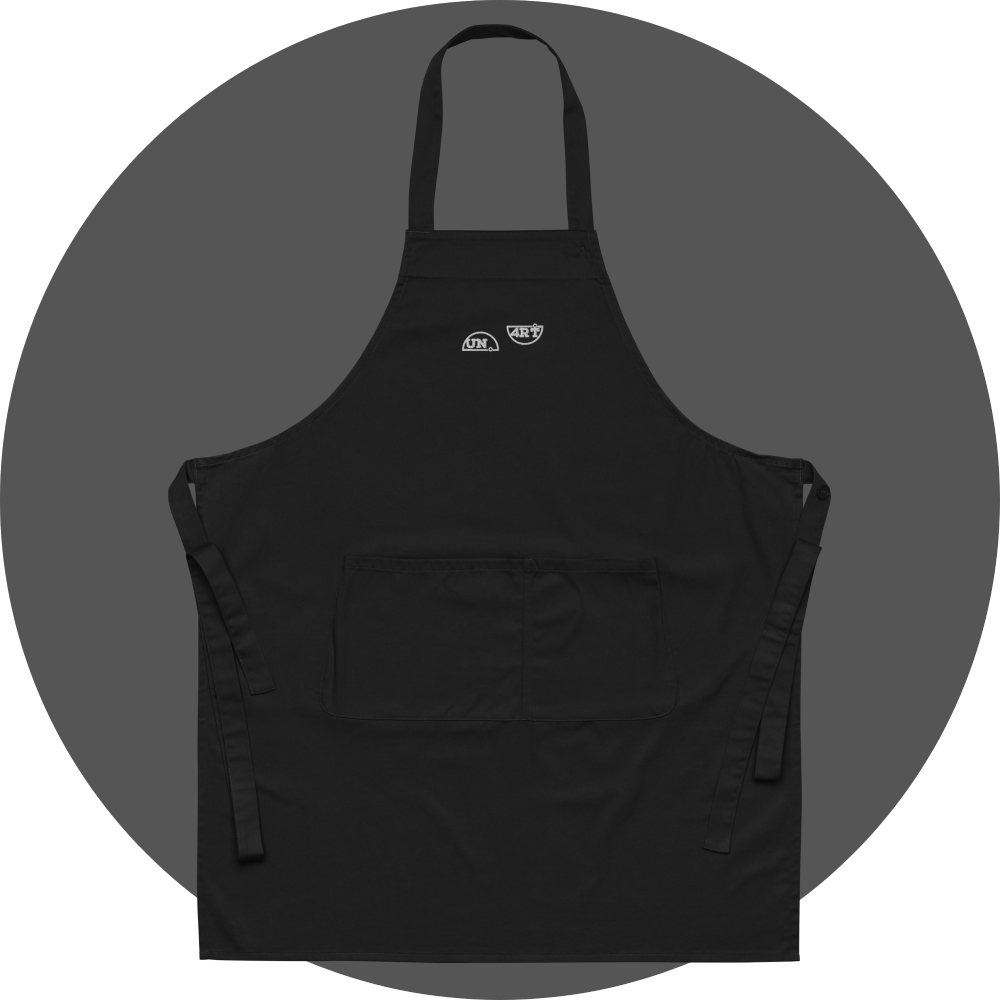 un4rt - the images shows a black apron with white embroidery of a splitted "UN4RT"-logo. 